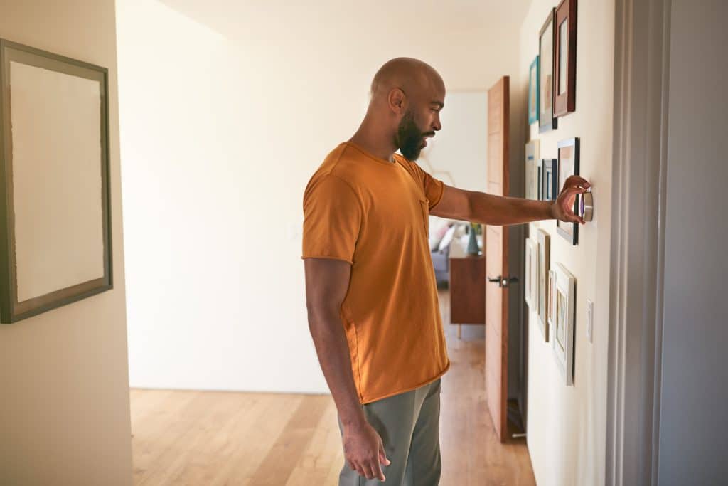 image of man troubleshooting thermostat battery problem